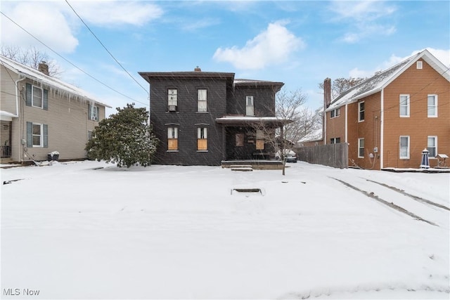 view of snow covered rear of property