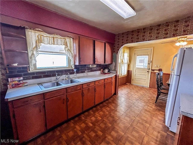 kitchen featuring a wealth of natural light, sink, and white refrigerator