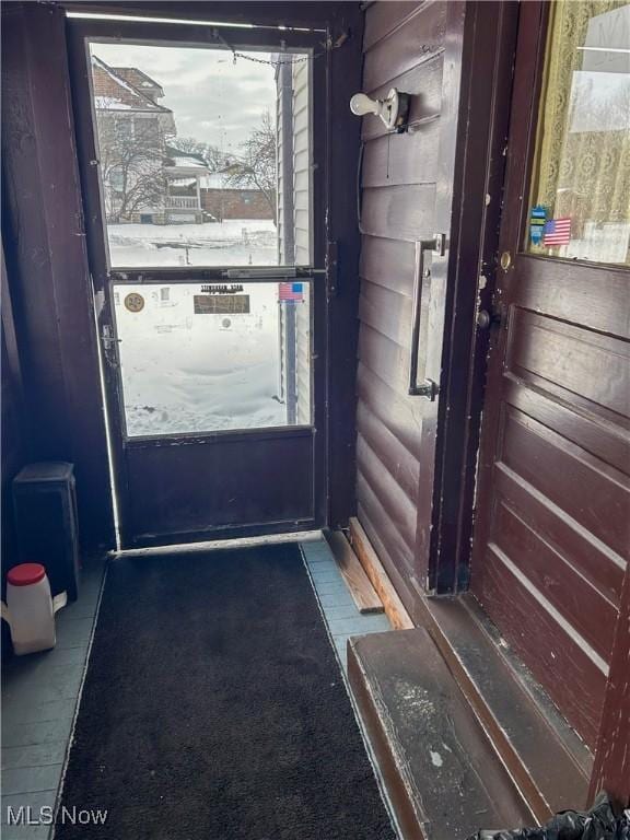 doorway featuring wooden walls and rustic walls