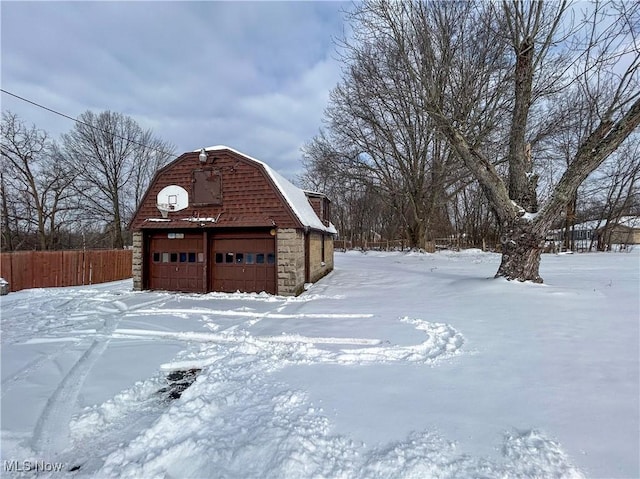 yard covered in snow with a garage and an outbuilding