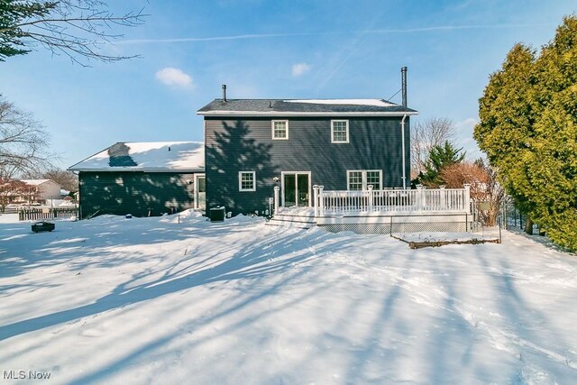 snow covered house featuring a wooden deck