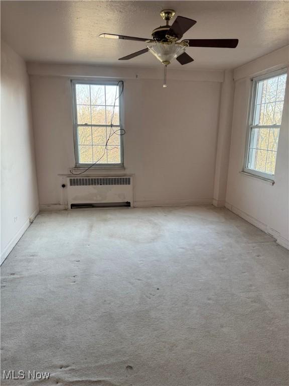 empty room featuring radiator and carpet flooring