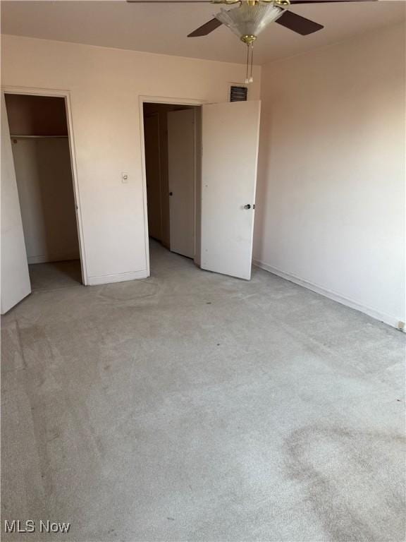 unfurnished bedroom featuring light carpet, visible vents, baseboards, and ceiling fan