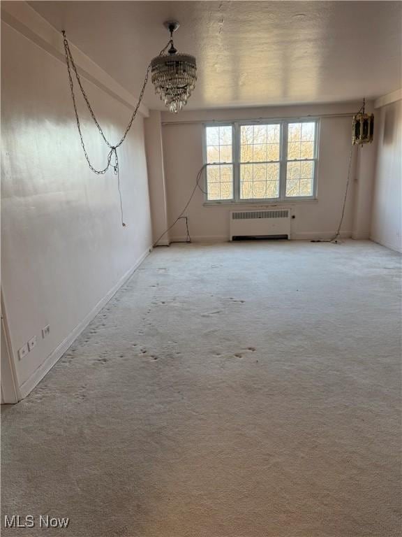 unfurnished room with carpet flooring and radiator