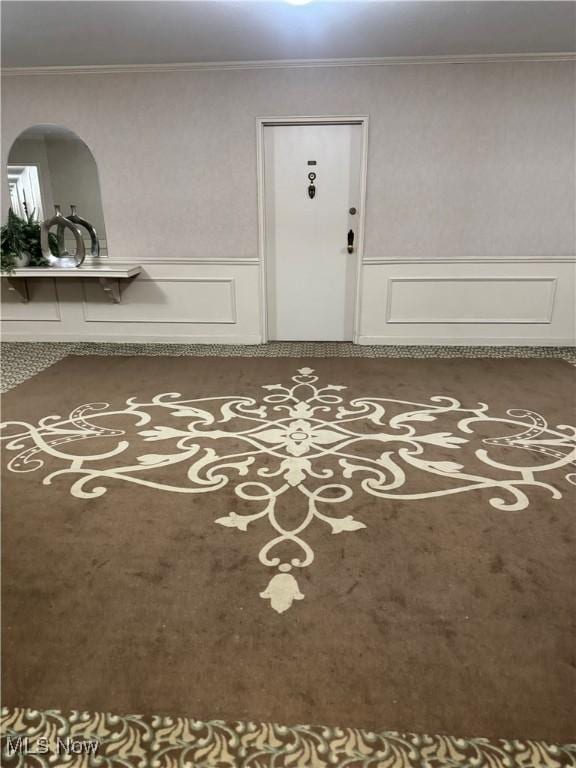 empty room with ornamental molding and wainscoting