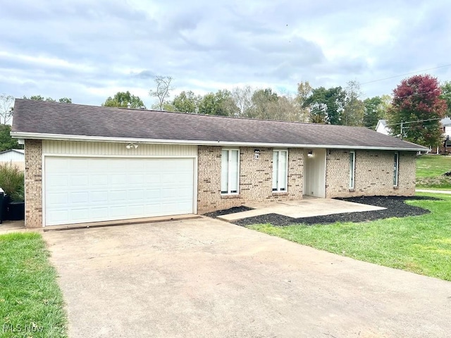 ranch-style house with driveway, a shingled roof, a front yard, an attached garage, and brick siding