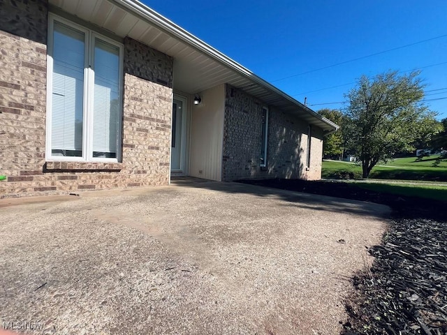 view of home's exterior with brick siding and driveway