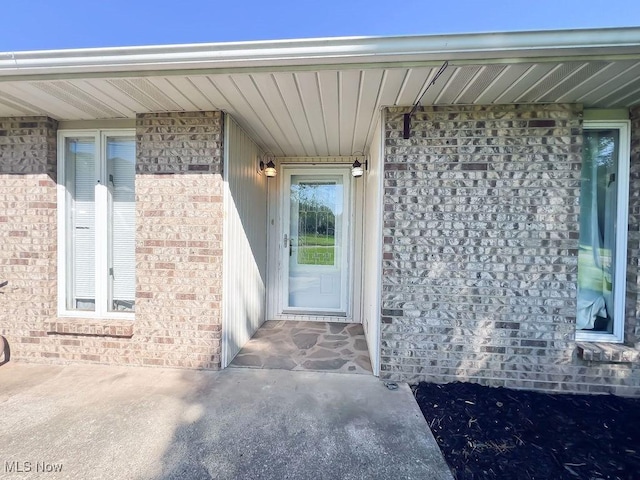 view of exterior entry with brick siding