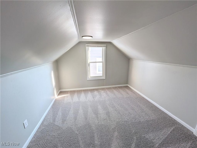 bonus room featuring light colored carpet and vaulted ceiling