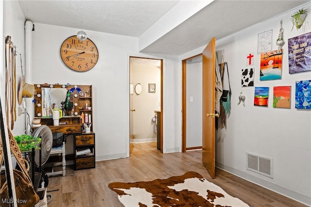 bedroom with a textured ceiling and light hardwood / wood-style floors