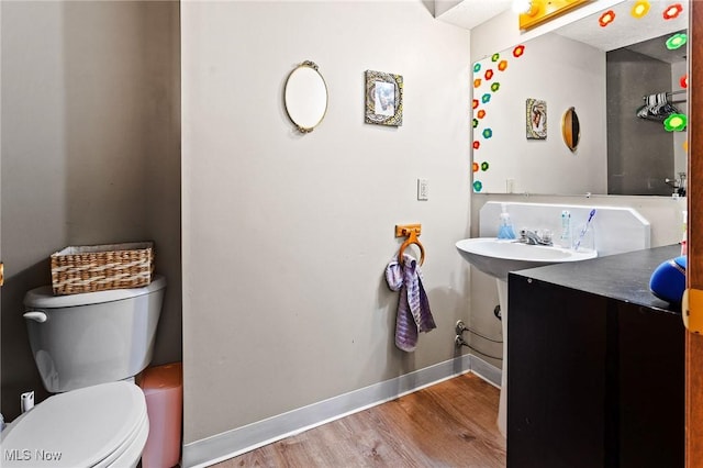 bathroom featuring wood-type flooring, toilet, and vanity