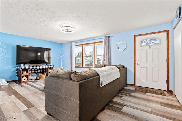 living room with a textured ceiling and light hardwood / wood-style flooring