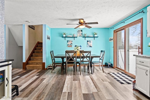 dining area featuring a textured ceiling, ceiling fan, and light hardwood / wood-style flooring