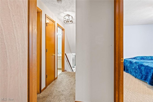 hall featuring a textured ceiling and carpet