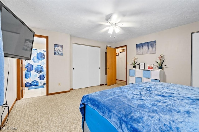 bedroom with ceiling fan, carpet, and a textured ceiling