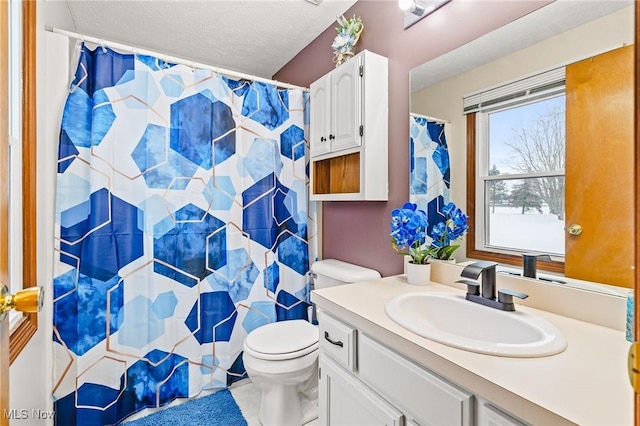 bathroom featuring toilet, vanity, a shower with curtain, and a textured ceiling