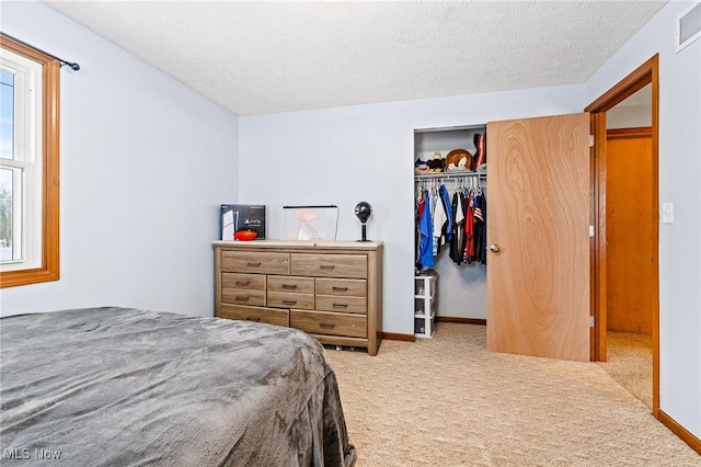 carpeted bedroom with a closet and a textured ceiling