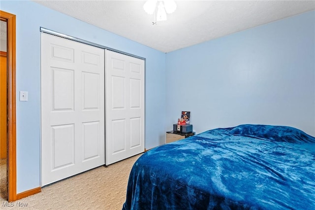 carpeted bedroom featuring ceiling fan and a closet