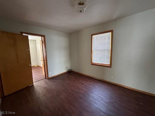 empty room with dark hardwood / wood-style flooring