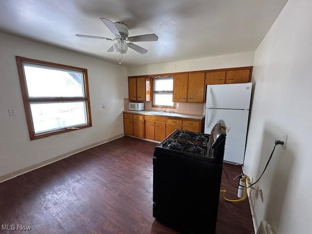 kitchen with ceiling fan, backsplash, plenty of natural light, and white appliances