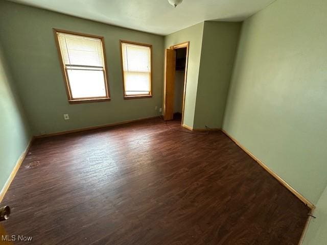 empty room with dark wood-type flooring