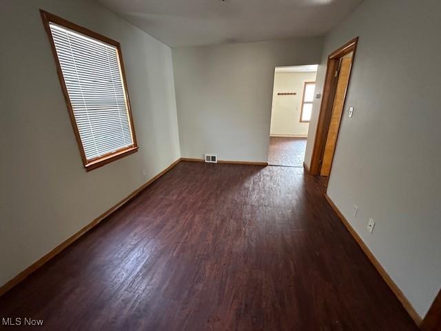 unfurnished room with dark wood-type flooring