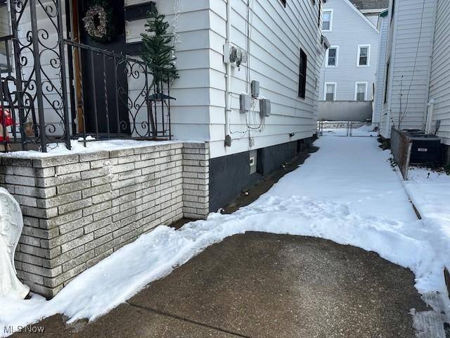 view of snow covered exterior with cooling unit