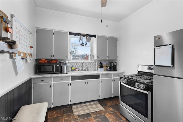 kitchen featuring ceiling fan with notable chandelier, stainless steel appliances, sink, backsplash, and gray cabinets