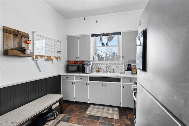 kitchen with sink, tasteful backsplash, and stainless steel refrigerator