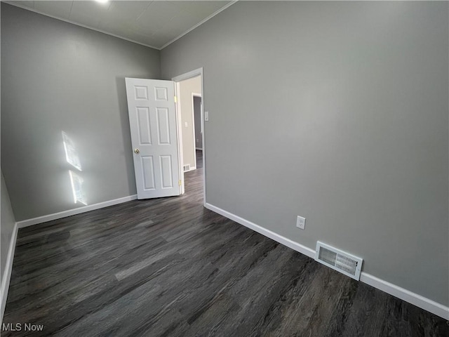 unfurnished room with dark wood-type flooring and crown molding