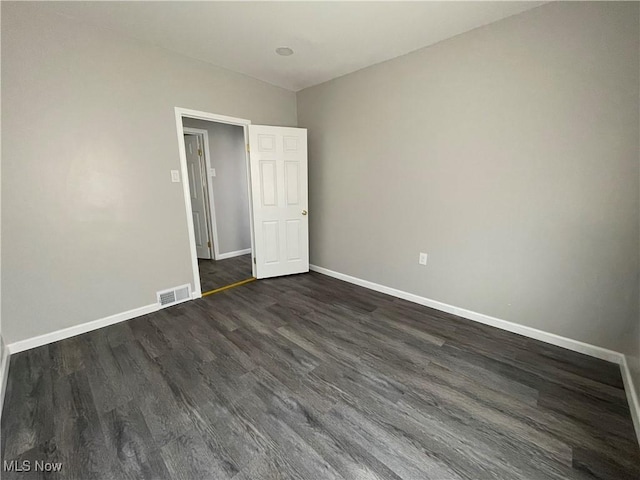 unfurnished bedroom with dark hardwood / wood-style flooring