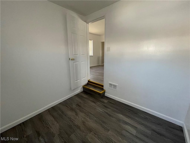 unfurnished room with dark hardwood / wood-style flooring