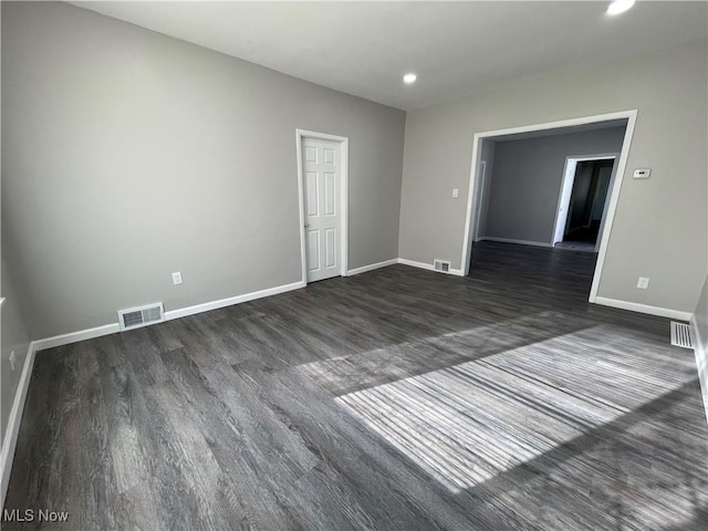 spare room featuring dark wood-type flooring