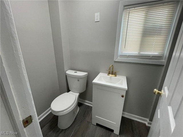 bathroom with hardwood / wood-style flooring, toilet, and vanity