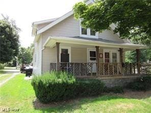 bungalow-style home featuring covered porch and a front lawn