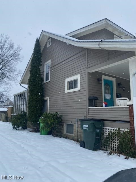 view of snowy exterior with covered porch