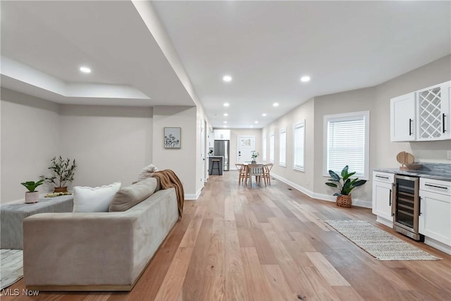 living room featuring bar, light hardwood / wood-style floors, and wine cooler