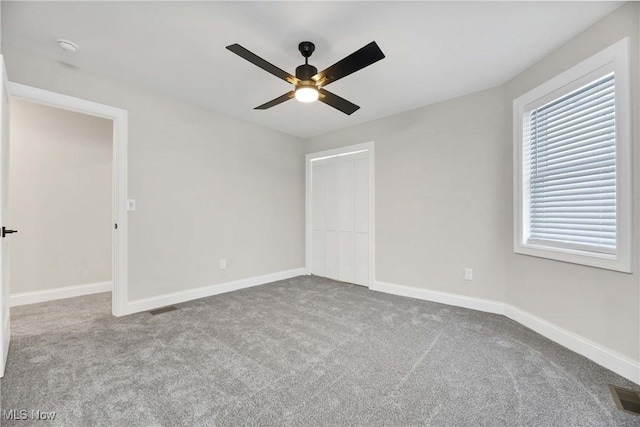 unfurnished room with ceiling fan and carpet floors