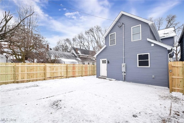 view of snow covered rear of property