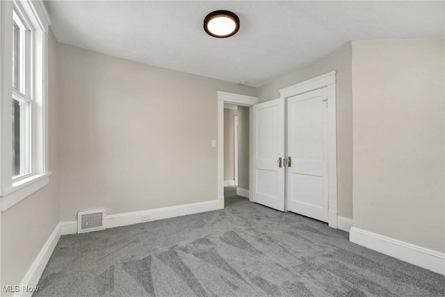 unfurnished bedroom with light colored carpet