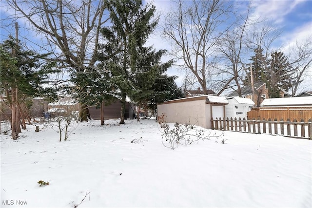 yard layered in snow with an outdoor structure