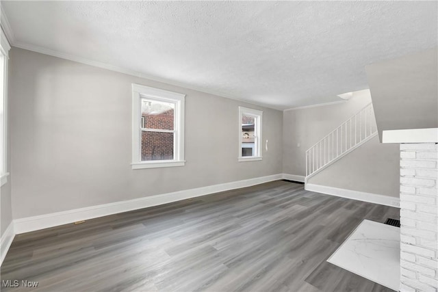 unfurnished room featuring a textured ceiling, crown molding, and dark hardwood / wood-style floors