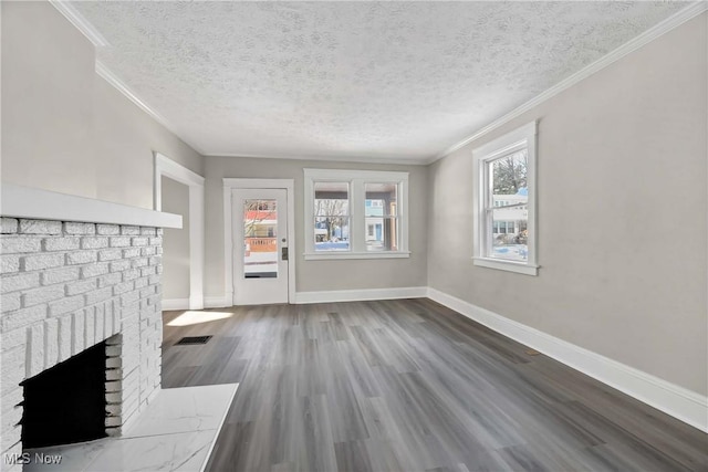 unfurnished living room with a brick fireplace, a textured ceiling, ornamental molding, and hardwood / wood-style floors