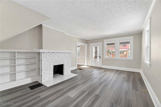 unfurnished living room with a brick fireplace, a textured ceiling, and hardwood / wood-style floors