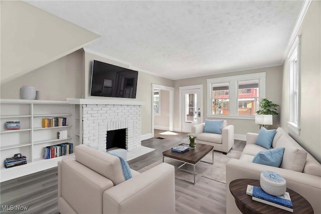 living room featuring a brick fireplace and light hardwood / wood-style flooring