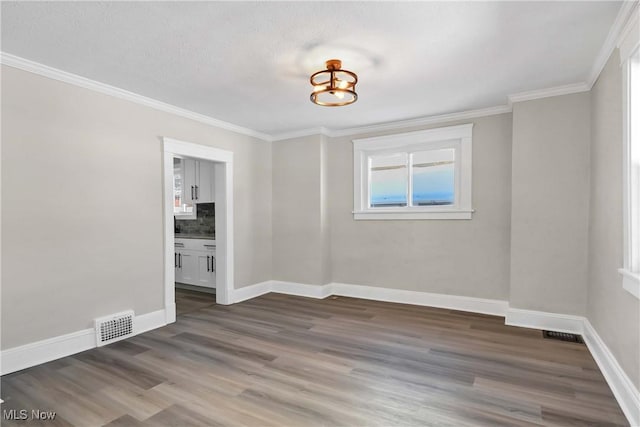 spare room with dark wood-type flooring and crown molding