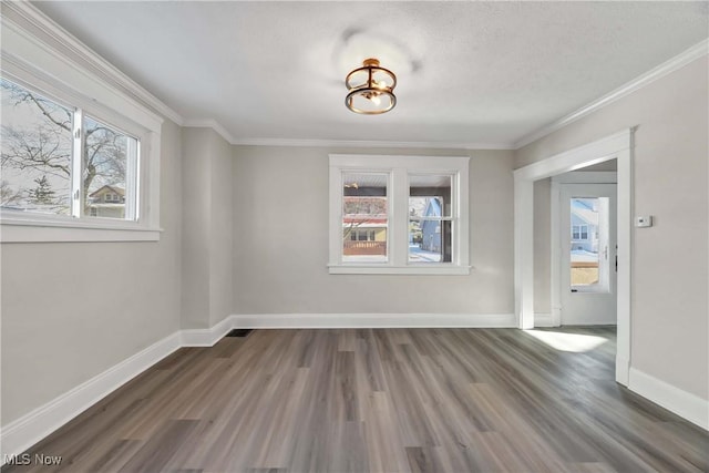 spare room featuring a textured ceiling, dark hardwood / wood-style floors, and ornamental molding