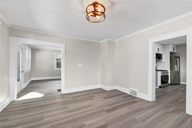 unfurnished room featuring ornamental molding and hardwood / wood-style flooring