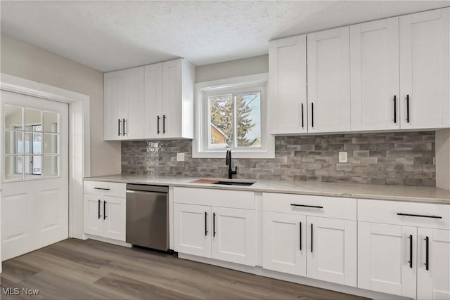 kitchen with white cabinetry, tasteful backsplash, a textured ceiling, stainless steel dishwasher, and sink