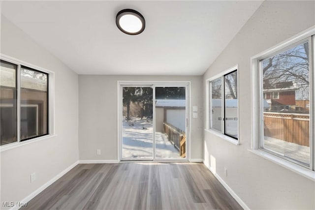 empty room featuring hardwood / wood-style floors and vaulted ceiling